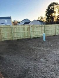 Newly installed wooden residential fence with no paint.